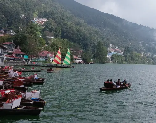 Best places to visit in Jim Corbett nearby destinations featuring the beautiful Naini Lake town surrounded by green hills.